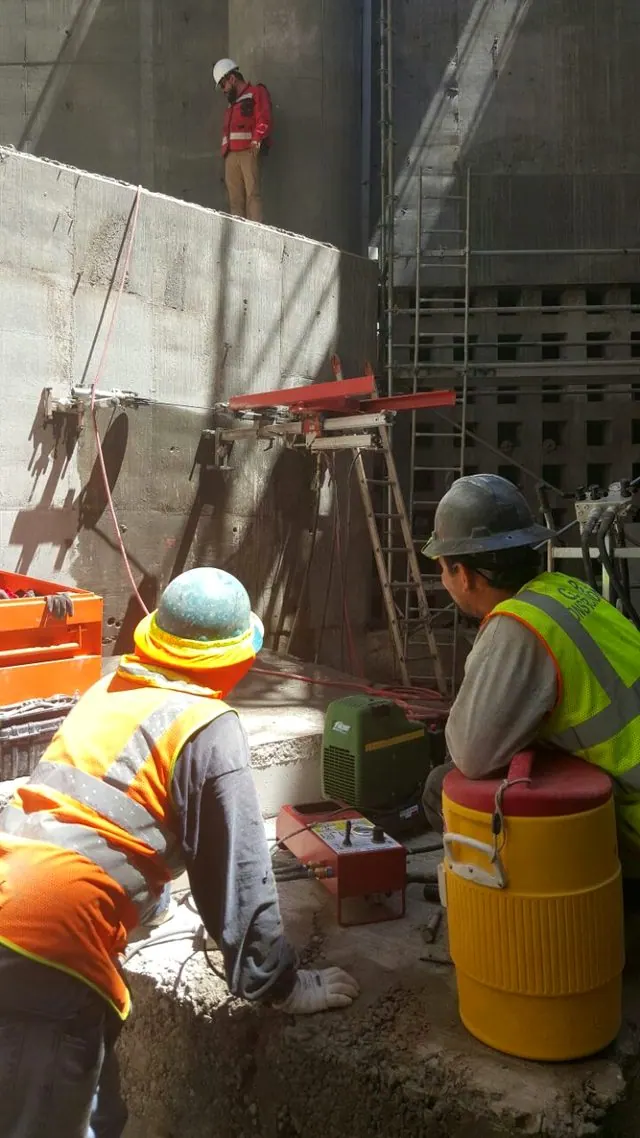 Crew running the diamond wire saw on a thick concrete wall