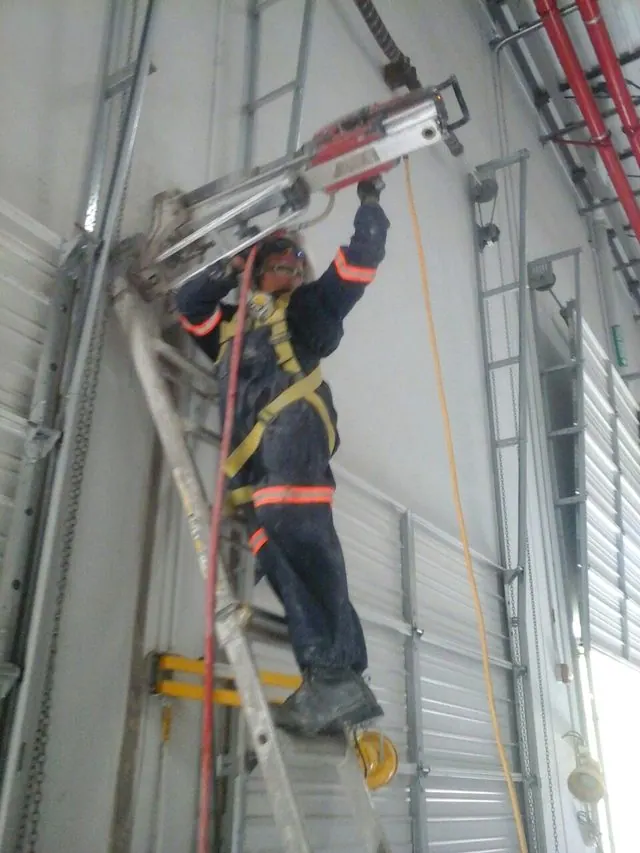Perforación de muro de concreto desde escalera en nave industrial
