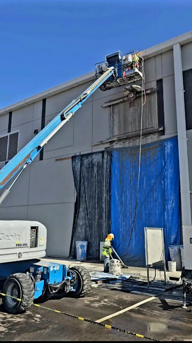 Corte de muro Tilt Up en fachada exterior desde plataforma de brazo articulado